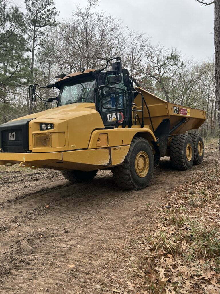 Caterpillar articulated dump truck hauling material for excavation and site work in Anderson, TX
